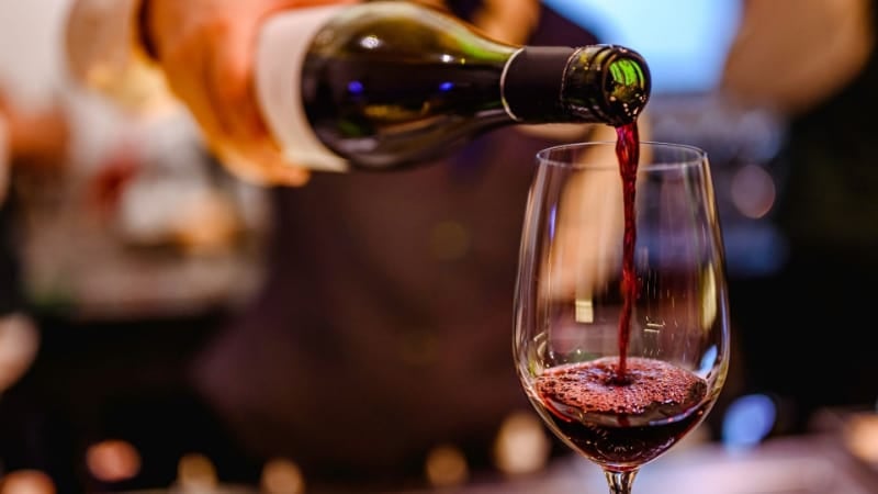 a_bottle_of_wine_being_poured_to_a_wine_glass